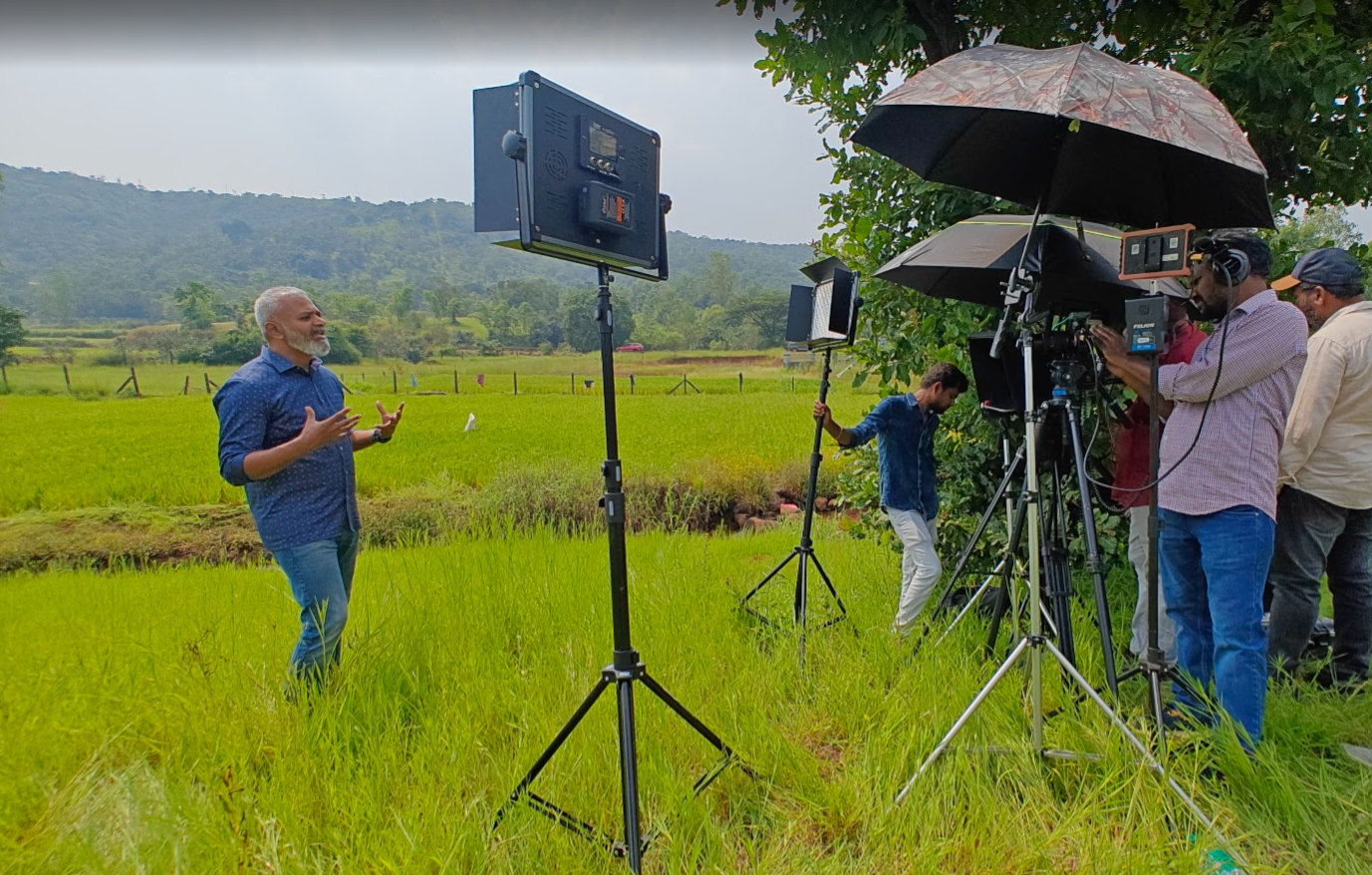 Field production shoot with lighting and camera crew
